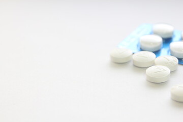 Pills in pill packs placed on a white table.