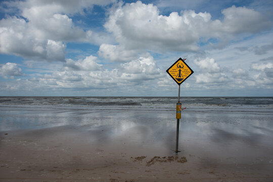 Gelbes Warnschild  am Strand in Holland
