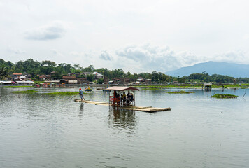 Obraz premium Tourists using raft enjoying Beautiful View of Bagendit Lake in Garut, West Java, Indonesia. Lake Bagendit is a popular tourist destination in Garut Regency.