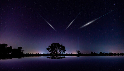 meteorites fly in the night sky. Bright meteors glow in the atmosphere. Beautiful shooting stars.