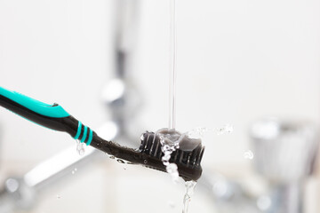 black tooth brush in a bathroom setting closeup 