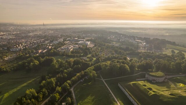 Fort Oberer Kuhberg and Ulm city on sunny golden morning low clouds time lapse