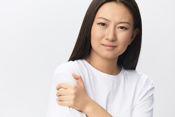 Suffering from neuralgia after sleeping in wrong position tanned beautiful young Asian woman touching painful shoulder isolated at white background. Injuries Poor health Illness concept. Cool offer