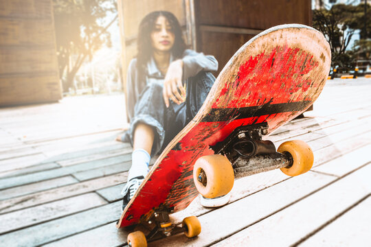 hermosa imagen de patineta roja alzada por patinadora con crespos en día soleado 