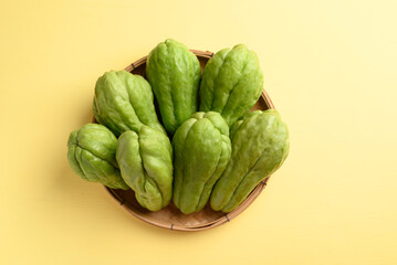 Chayote squash fruit on yellow, Organic vegetables from local market