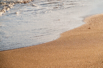 Soft wave of the sea on the sandy beach.