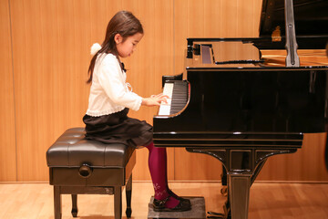 発表会でピアノを演奏する女の子