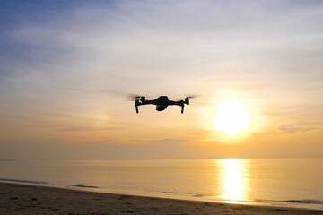 Aerial drone with digital camera captures impressive and spectacular sunsets at the beach by the sea. concept of technology and tourism