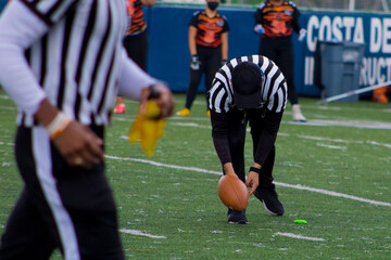 Arbitro de football americano colocando balon 