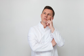 Handsome doctor against white background with copy space