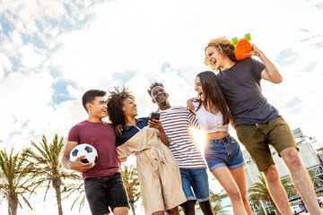 Group of multiethnic young adult friends laughing together outdoors - Millennial diverse people...