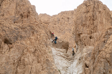 Fototapeta premium Experienced athletes start the descent with the equipment for snapping in the mountains of the Judean Desert near the Tamarim stream near Jerusalem in Israel