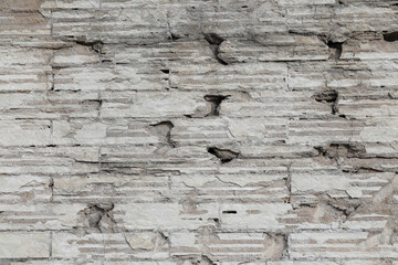 Cement wall with uneven surface and bricks, rough structure and cracked wall background