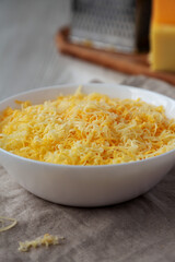 Shredded Mexican Cheese Mix in a White Bowl, low angle view.