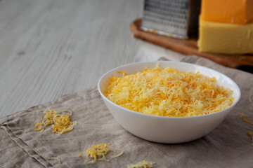 Shredded Mexican Cheese Mix in a White Bowl, side view. Copy space.
