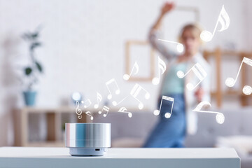 Wireless portable speaker in room and dancing woman on background