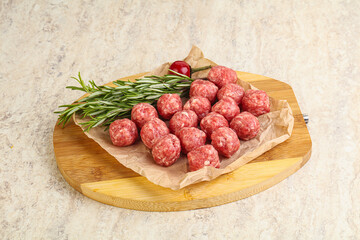 Raw uncooked beef meatballs served rosemary