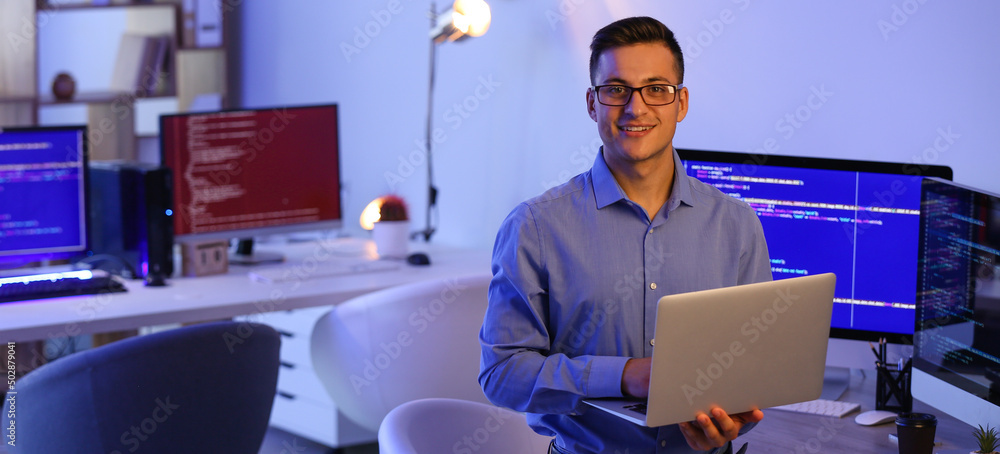 Poster portrait of handsome programmer with laptop in office