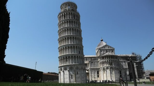 Quiet scene of the Leaning Tower of Pisa leaning to the left without fence and just a few people