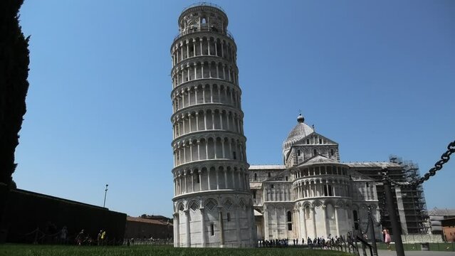Quiet scene of the Leaning Tower of Pisa leaning to the left without fence and just a few people