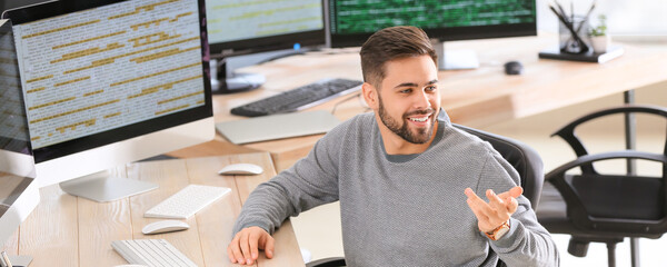 Male programmer talking to colleague in office