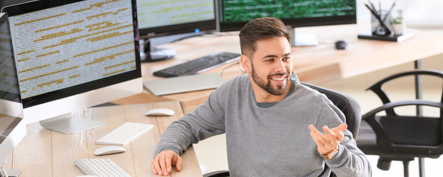 Male programmer talking to colleague in office