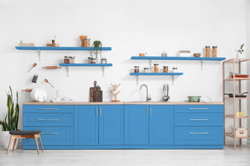 Interior of light kitchen with blue furniture