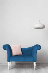 Blue lounge with pillow near light wall