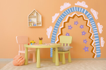 Stylish interior of modern playroom with painted rainbow on wall
