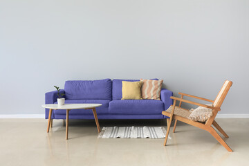 Interior of stylish living room with modern armchair, sofa and table