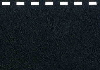 High resolution close up dark gray, black uncoated paper texture scan with square holes for notebook cover spiral binding string pattern office notebook cover with copy space for text
