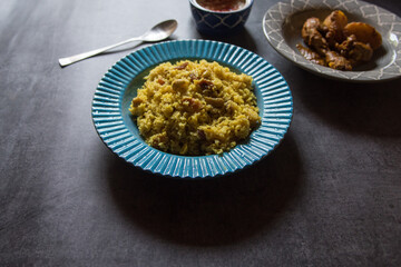 Pulao or basmati rice made with Indian spices and dry fruits served in a blue bowl. Close up,...