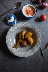 Popular Indian menu chicken curry in a bowl along with condiments. Top view, selective focus.