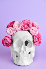 Human skull with flowers on purple background