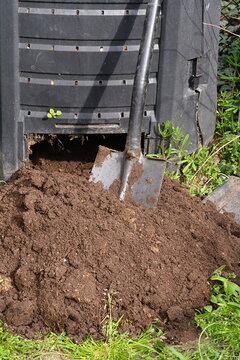 digging soil from a composter in the garden