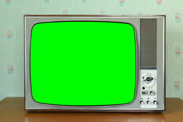 Old vintage green screen TV in a room with vintage wallpaper. Interior in the style of the 1960s.