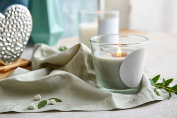 Holder with burning candle on table, closeup
