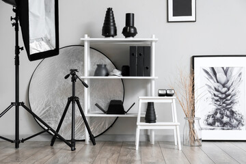 Stepladder stool and shelf unit with professional equipment in stylish photo studio