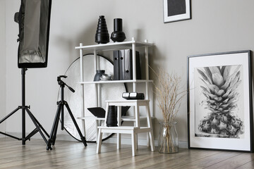 Stepladder stool and shelf unit with different professional equipment in stylish photo studio interior