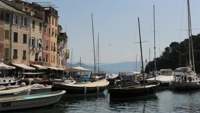 Close shot of quiet fishing village Portofino, Italy facing the open water in the summer with small boats in de harbour