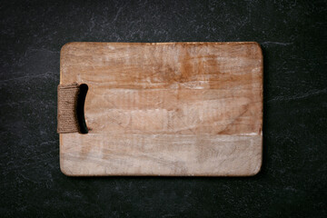Empty cutting wood board on dark marble background, layout image