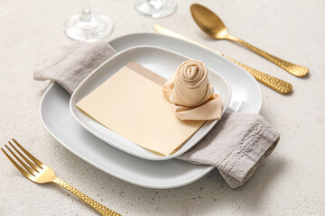 Table setting with blank card on light background, closeup