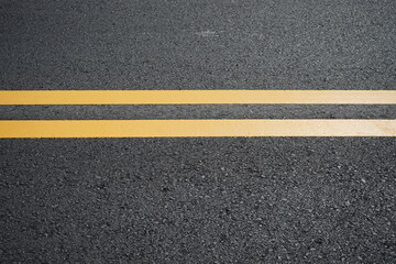 Blurred image of yellow traffic marking work on paved road