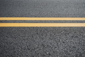 Blurred image of yellow traffic marking work on paved road