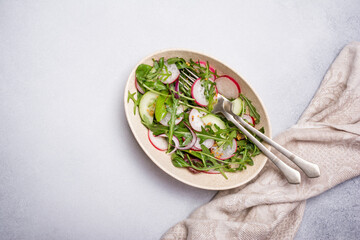 Healthy vegetarian salad with fresh radish, cucumber, onion and mix of green leaves
