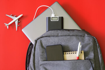 Backpack and modern gadgets: laptop, external battery power bank, mobile phone, notepad and pen. On...