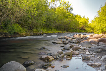 Flowing river with silk effect and rocks on the sides in southern Chile