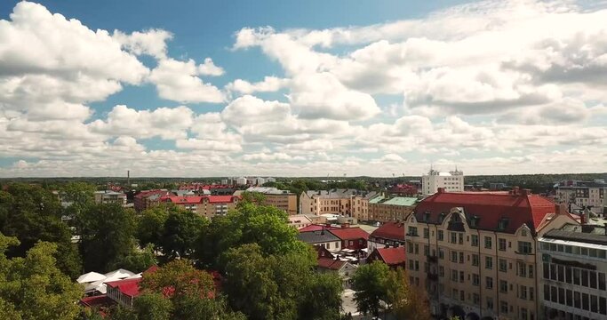 Ascending Aerial 4k view of Swedish city Orebro, summer in Sweden. houses, river, sky full of clouds