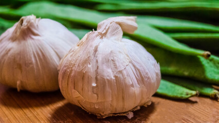 Garlic and green beans on wooden board