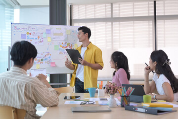 Interested young employees listening to male team leader explaining new project strategy on whiteboard.